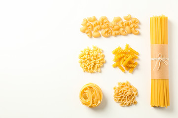 Flat lay composition with different pasta on white background, space for text