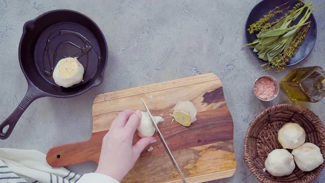 Flat lay. Preparing garlic spread by roasting garlic with fresh spices in cast iron frying pan.