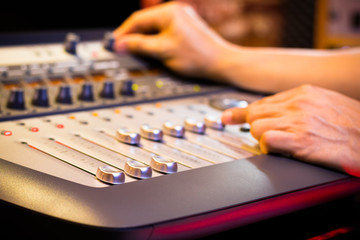male sound engineer, dj hand working on audio mixing console in recording, editing, broadcasting...