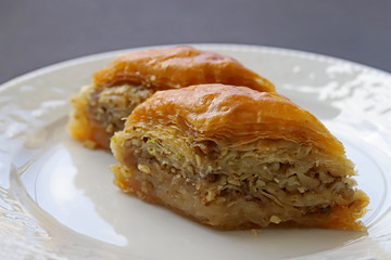  TÜRKÇE Beyaz tabak içerisnde cevizli baklava tatlısı 45 / 10000 İNGİLİZCE Çeviri yap:GoogleBing Dessert baklava with walnuts in a white dish