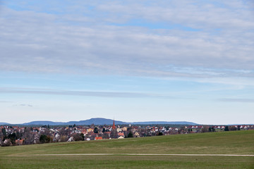 Fototapeta na wymiar Minimalistic shot of the town called Heroldsberg near Nuremberg in Franconia / Bavaria with the hill called Moritzberg in the background in the middle. Seen in March 2019