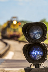 Railway traffic light with a blue standard signal. Railway crossing with semaphore and locomotive...