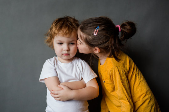 little girl kisses a disgruntled angry boy, the concept of children's relationships and friendship