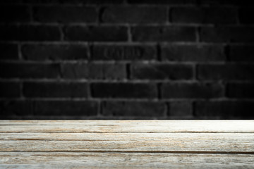 Old wooden table with brick background dark