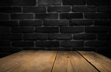 Old wooden table with brick background dark