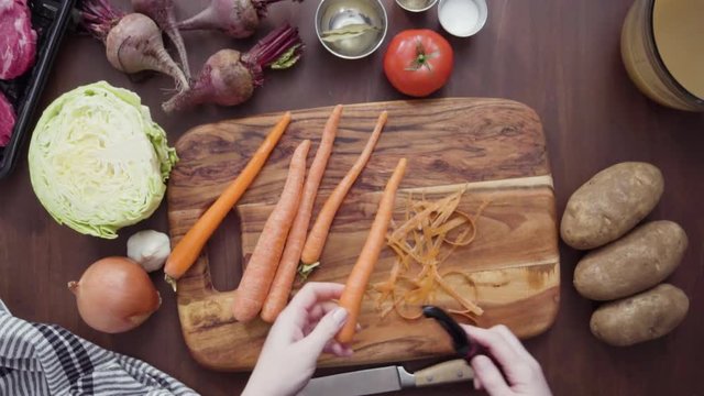 Step by step. Flat lay. Slicing orange carrots into the small cubes for beet soup, borscht.