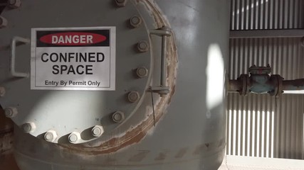 A very large confined space at a lead and zinc refinery showing confined space signage and entry points