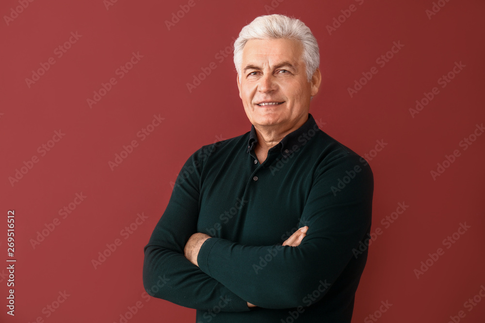 Poster Portrait of handsome senior man on color background