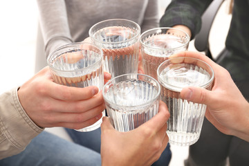 Group of people drinking water indoors, closeup