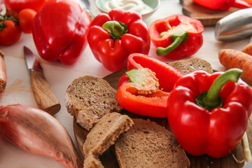 Ripe red pepper and plate with bread on table
