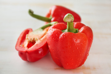 Ripe red peppers on white wooden background