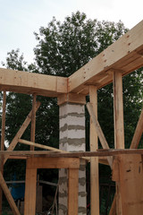 view of wooden formwork with holders, which will be filled with overlap between floors in country house under construction from foam block