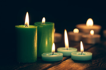 candles burning in darkness over black background. commemoration concept.