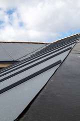 Fototapeta premium close up view of grey folding roof under construction on waterproofing layer