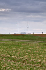 Two big antennas in a empty moody franconian landscape with fields and agriculture at the beginning of spring near Kalchreuth, Germany in March 2019