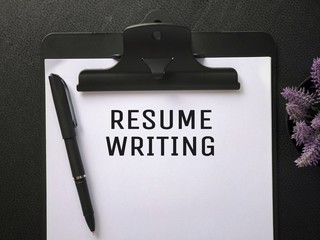 Business or Job Hiring concept - Top view of a clipboard and white sheet with RESUME  WRITING written on it.