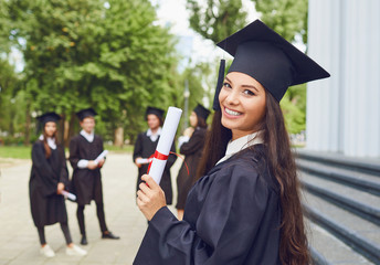 A young female graduate against the background of university graduates.