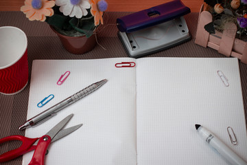 Scissors and writing equipments plus math book above textured backdrop