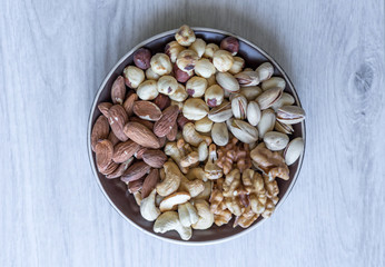 Healthy food. Nuts mix assortment on white grey table top view. Collection of different legumes for background image close up nuts, pistachios, almond, cashew nuts, peanut, walnut. image