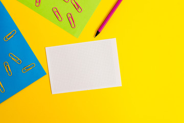 Blank paper sheets squared notebook pencil clips plain colored background