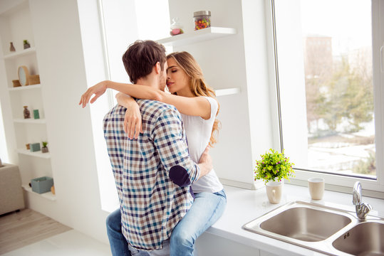 Close up photo pair beautiful he him his macho she her lady just married overjoyed hold each other hands bonding hugging touch lips going kiss desire apartments flat bright kitchen room indoors