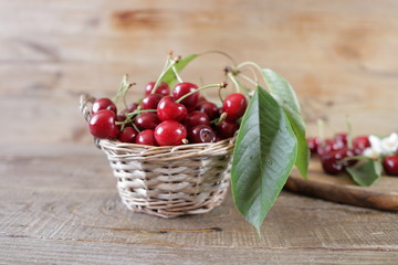 Fototapeta na wymiar sweet cherry on the background of natural wood in a straw basket