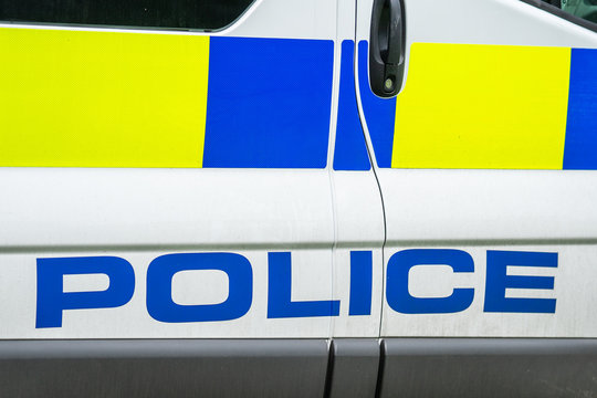 Fragment Of A White Police Car With A Word POLICE Spelled Out In Blue In England , Close Up