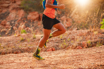 A man Runner of Trail . and athlete's feet wearing sports shoes for trail running in the mountains , soft focus and blurry