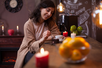 Portrait of attractive young caucasian woman eating cake at the bar counter in a hipster coffee shop