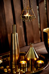 Cozy decor. Gold , burning candles Golden vessels 