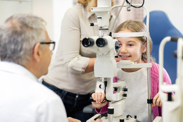 Mature doctor look with eye apparatus in child’s eye