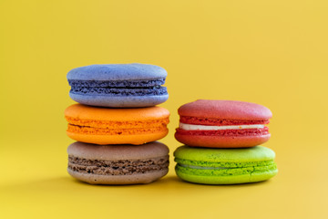  colorful macaroons isolated on yellow background. sweet biscuit. Traditional cake