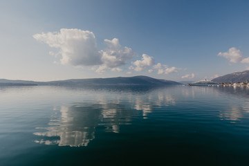 Small tourist villages on the Bay of Kotor in Montenegro, in a sunny summer day. The beginning of the cruise from Tivat city.