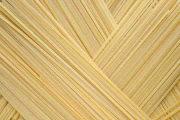Diagonal geometric pattern of pasta bavette. Traditional Italian cuisine. Background image of pasta from durum wheat.