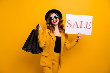 Close up photo beautiful she her lady recommend black friday carry packs paper promotion buy buyer birthday sale discount wear specs formal-wear costume suit isolated yellow bright background