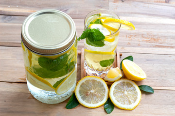 infused water lemon and mint on wood background , Fresh lemon and mint in water for healthy