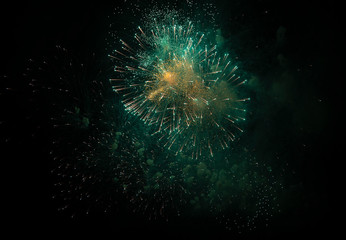 Fireworks against the dark sky. Bright salute in the black sky,