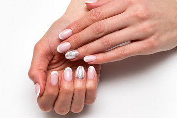 Naklejka premium Wedding manicure 2019. White French manicure on long oval nails with silver glitter triangles on the nameless nails against a white background.