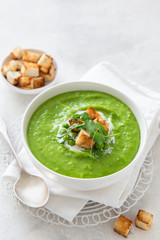 vegan green peas cream soup in white bowl