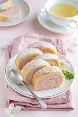 slised strawberry swiss roll  cake on white plate