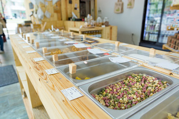 Different organic pasta in metal bowls ready for bulk shopping in zero waste store.