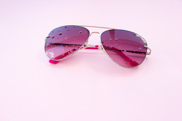 pink glasses on a pink background with copy space