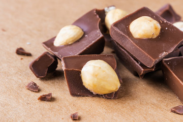 Slices of milk chocolate with hazelnuts close-up. Photo in warm colors. Sweetness. World chocolate day