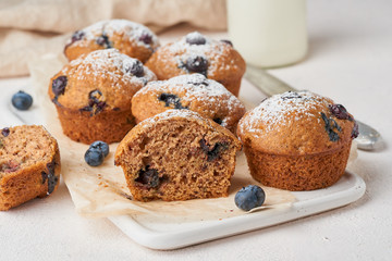 Blueberry muffin, side view, close up. Cupcakes section with berries on white concrete table