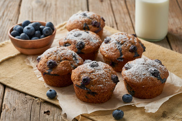 Blueberry muffin, side view. Cupcakes with berries on old linen napkin, rustic wooden table, breakfast with cake