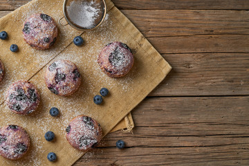 Blueberry muffin, top view, copy space. Cupcakes with berries on old rustic linen napkin, wooden table