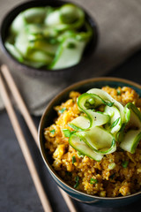 Traditional Burmese fried rice with shallots, turmeric and fresh cucumber strips mixed with chopped green onions and vinegar has been stir-fried in a wok and perfect for vegan. close-up,top view