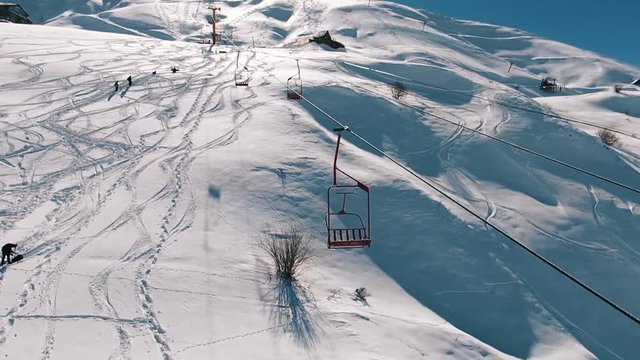 Slow motion: Camera moving close to the ski lifts in the mountains.