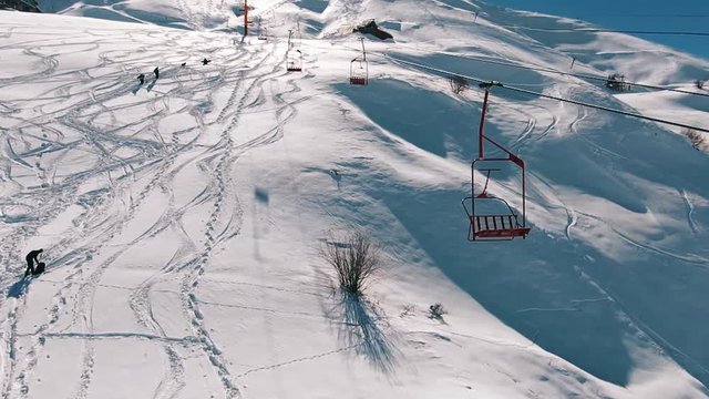 Slow motion: Camera moving close to the ski lifts in the mountains.