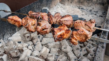 The meat is on charcoal close-up outdoors. Street food